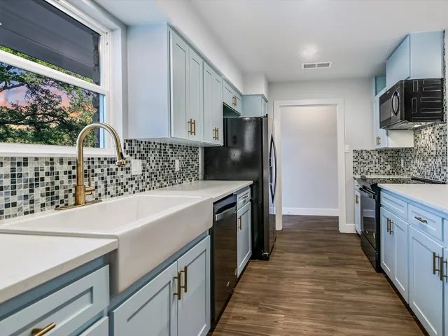 a kitchen with stainless steel appliances a sink stove and refrigerator