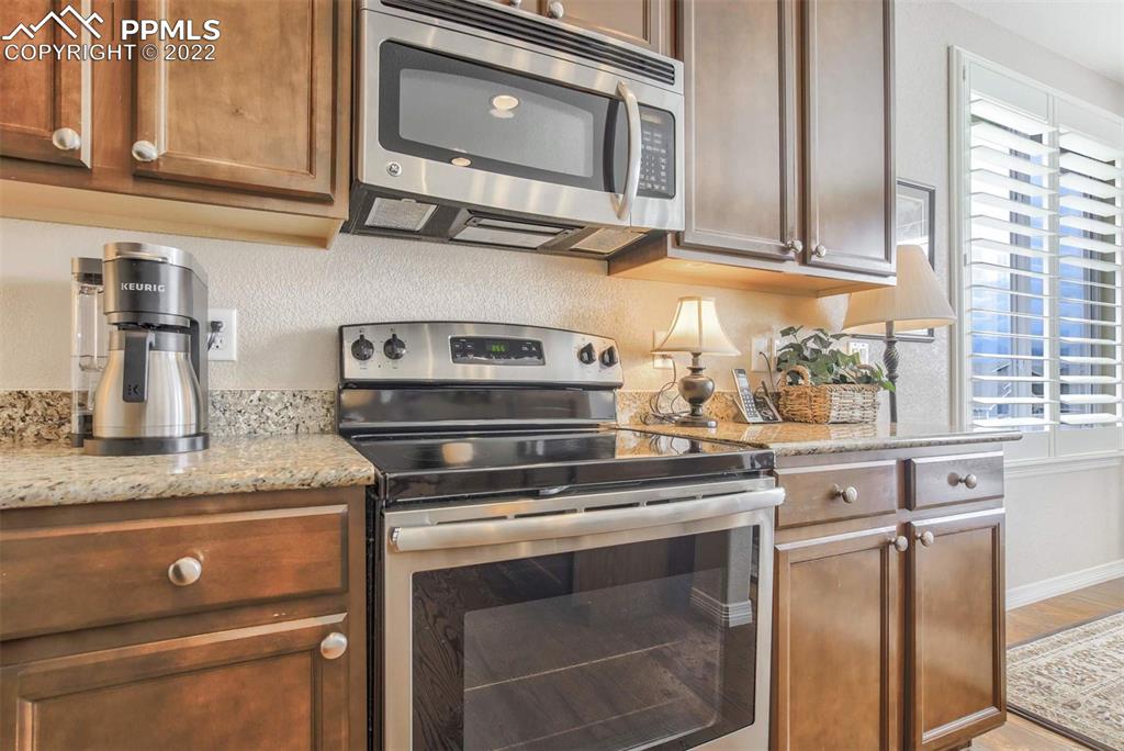 12410 Salmon Point Colorado Springs, CO 80921 - Photo 13 of 49 a kitchen with stainless steel appliances granite countertop a stove microwave and cabinets