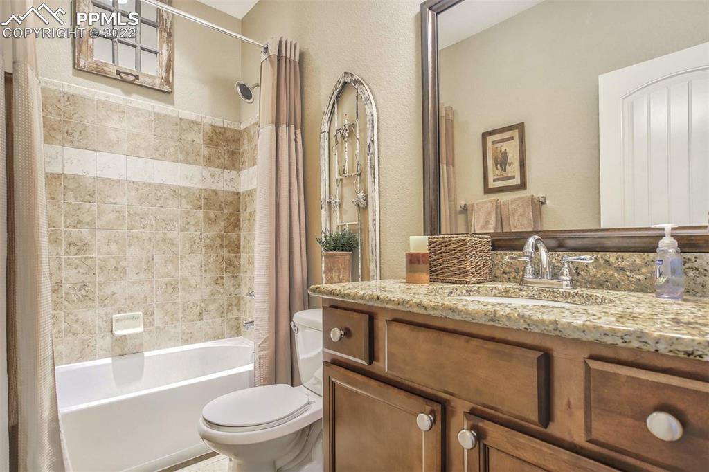 12410 Salmon Point Colorado Springs, CO 80921 - Photo 29 of 49 a bathroom with a granite countertop sink toilet and shower