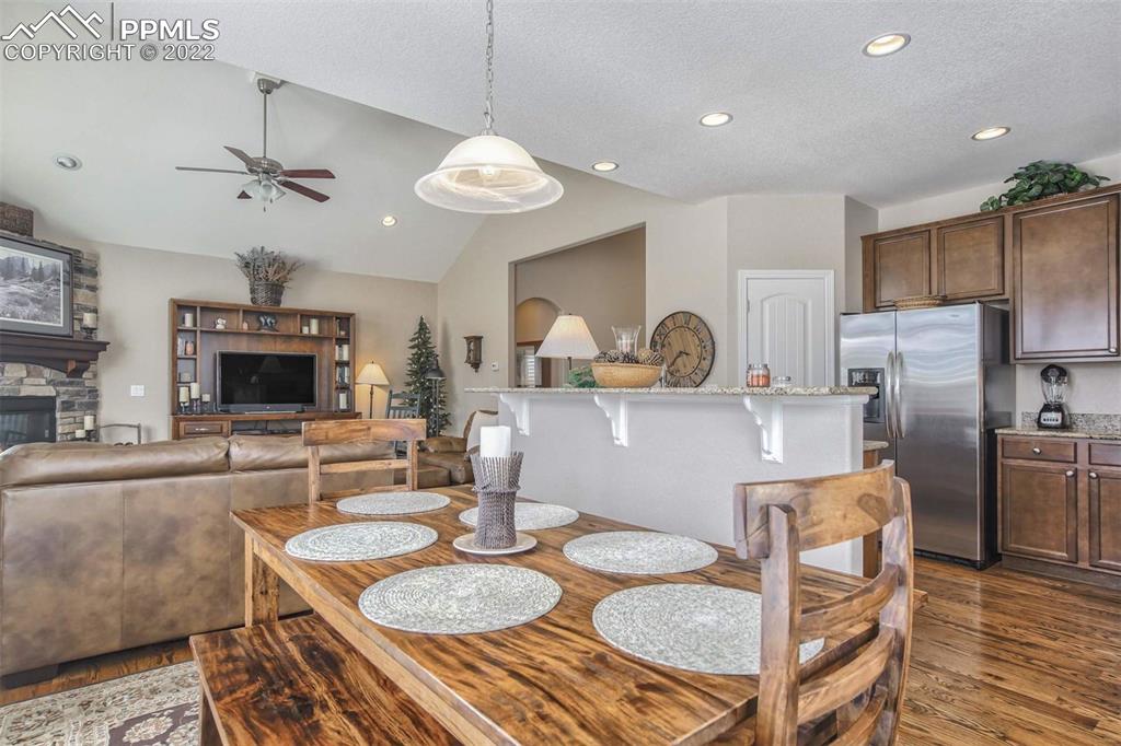 12410 Salmon Point Colorado Springs, CO 80921 - Photo 8 of 49 a kitchen with granite countertop kitchen island stainless steel appliances a dining table and chairs