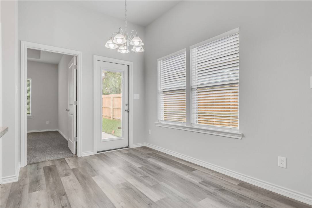 1805 Pin Oak Street Bryan, TX 77803 - Photo 12 of 20 Unfurnished dining area featuring a chandelier and light wood-style floors