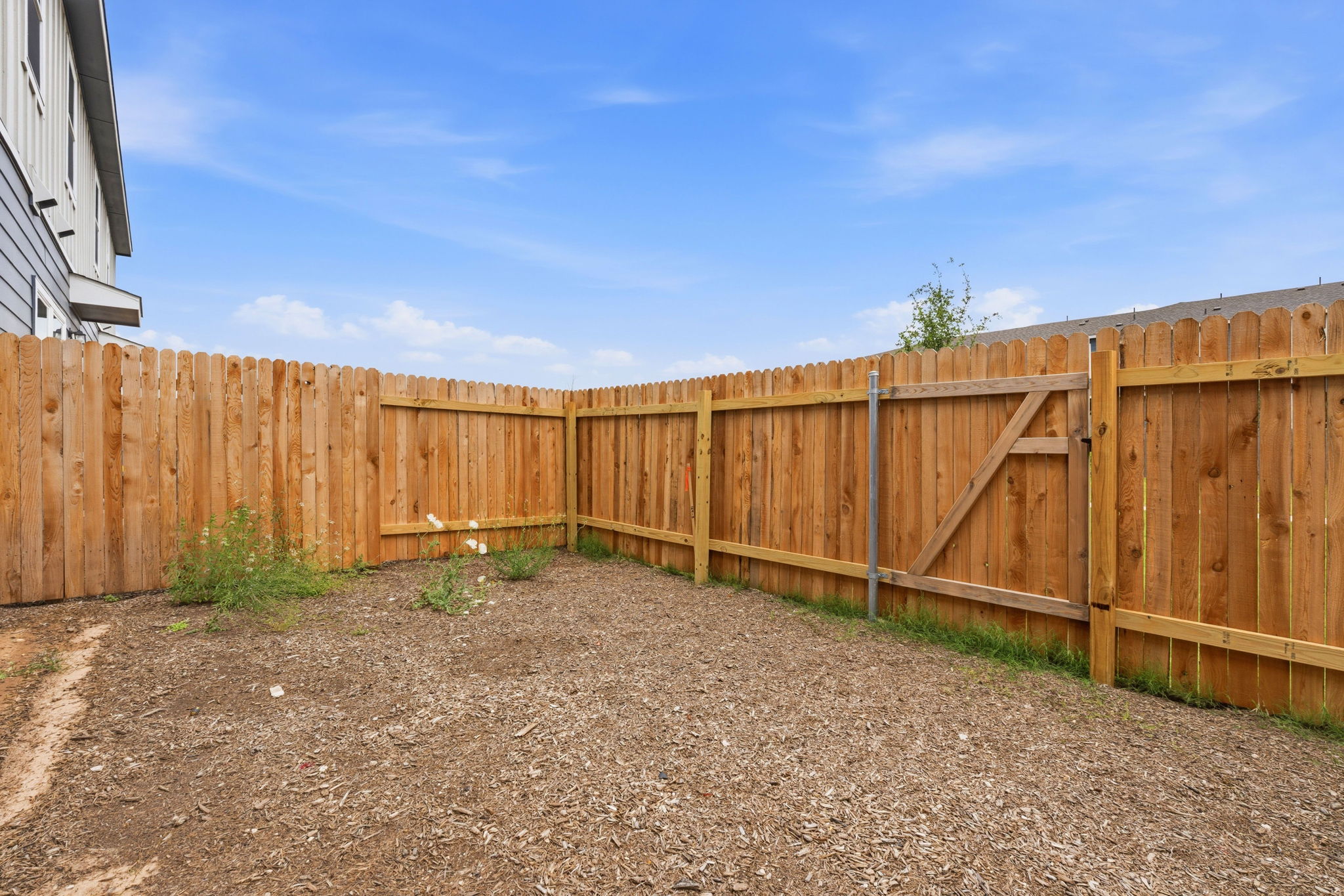 164 Cinnabar Lane, Unit 3 Kyle, TX 78640 - Photo 19 of 20 Private backyard featuring a wood privacy fence with a scalloped top and a functional gate