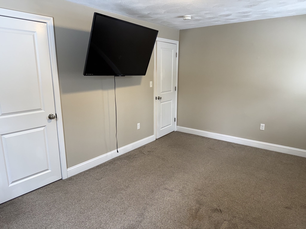 9 Rickard Street Carver, MA 02330 - Photo 12 of 26 a view of an empty room with wooden floor