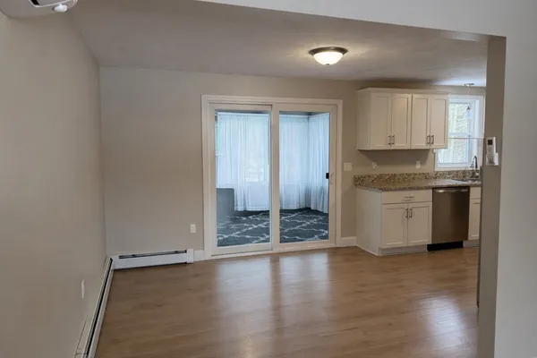 a view of a kitchen with a sink and dishwasher white cabinets with wooden floor