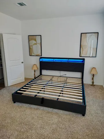 a view of a bedroom with wooden floor and cabinet