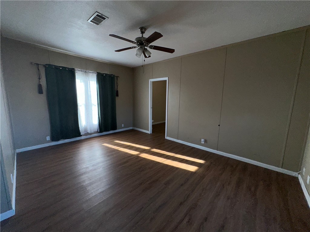 Undisclosed Address Robstown, TX 78380 - Photo 12 of 17 a view of empty room with wooden floor and fan