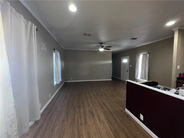 a view of a hallway with wooden floor and staircase