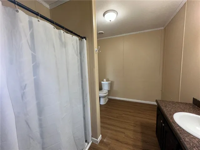 a bathroom with a granite countertop sink and a toilet