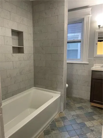 a bath tub sitting next to a bathroom sink