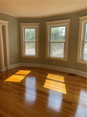 a view of empty room with wooden floor and windows