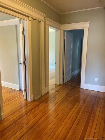 a view of a room with wooden floor and a window