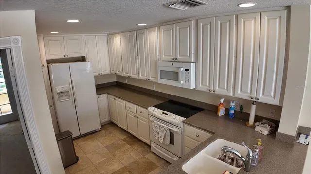 a kitchen with granite countertop a refrigerator and a sink