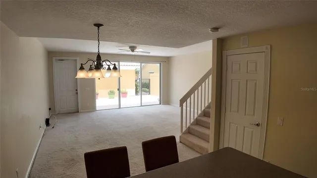 a view of a livingroom with furniture staircase and a ceiling fan