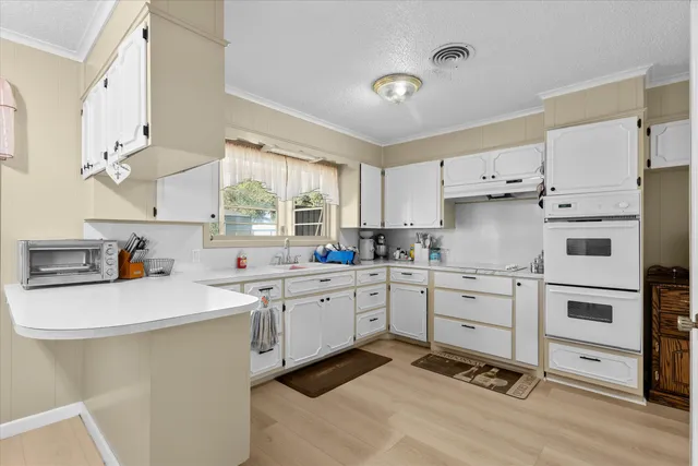 a kitchen with white cabinets appliances and a sink