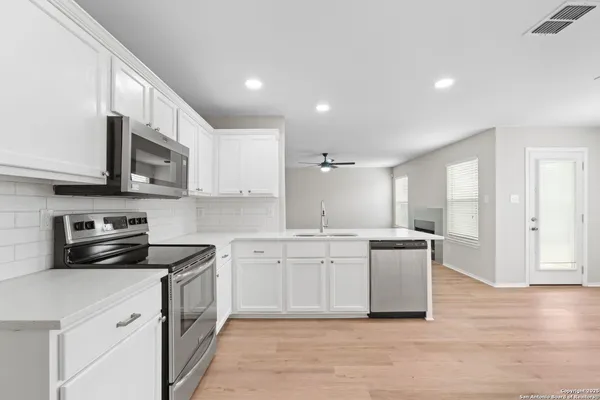 a kitchen with stainless steel appliances granite countertop a stove a sink and a microwave