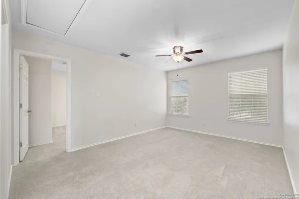 a view of an empty room with a ceiling fan and a window