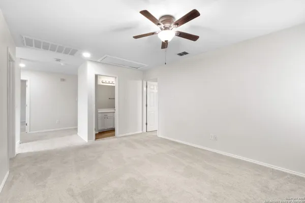 an empty room with a ceiling fan and a window