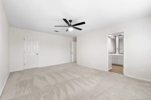 a view of an empty room with a ceiling fan