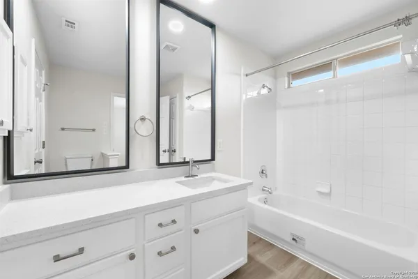 a bathroom with a bathtub shower and a sink