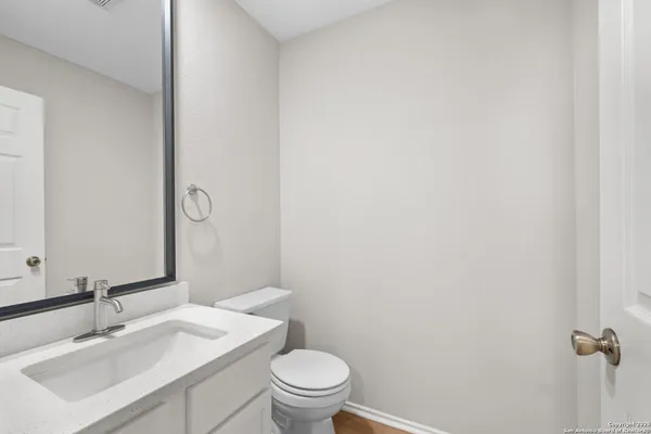 a bathroom with a sink vanity mirror and toilet