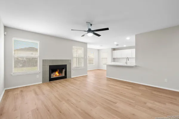 a view of empty room with wooden floor and fireplace