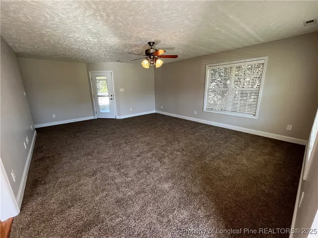 a view of a livingroom with a ceiling fan and window