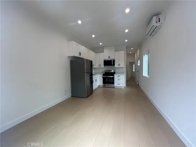 a kitchen with refrigerator and cabinets