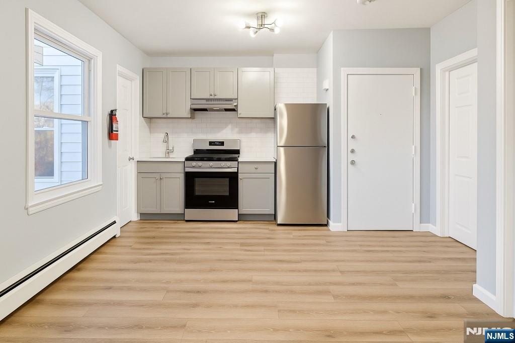 42 Lester Street Wallington, NJ 07057 - Photo 6 of 9 a view of kitchen with stainless steel appliances wooden floor and window
