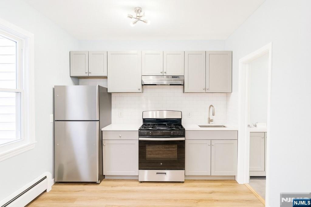 42 Lester Street Wallington, NJ 07057 - Photo 7 of 9 a kitchen with a refrigerator stove and white cabinets