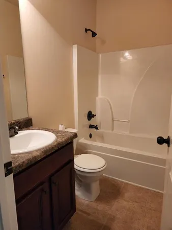 a bathroom with a granite countertop sink a toilet and shower