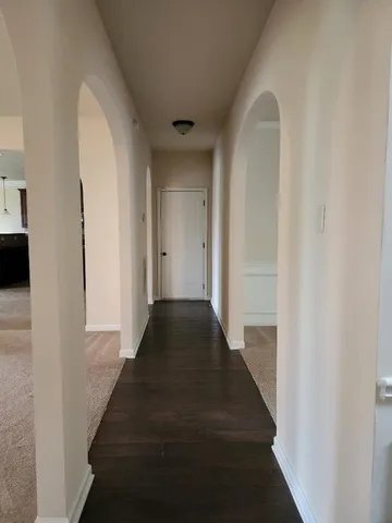 a view of a hallway with wooden floor and staircase