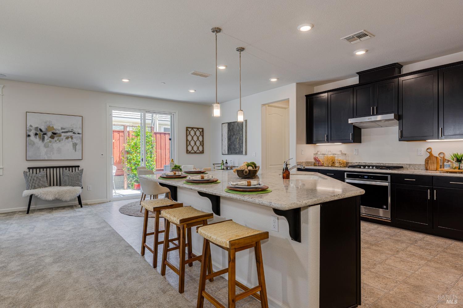 a kitchen with a sink dining table and chairs