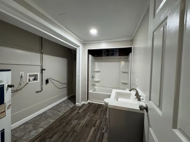 a bathroom with a granite countertop sink a mirror and shower
