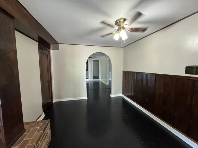 a view of a hallway with wooden floor and chandelier