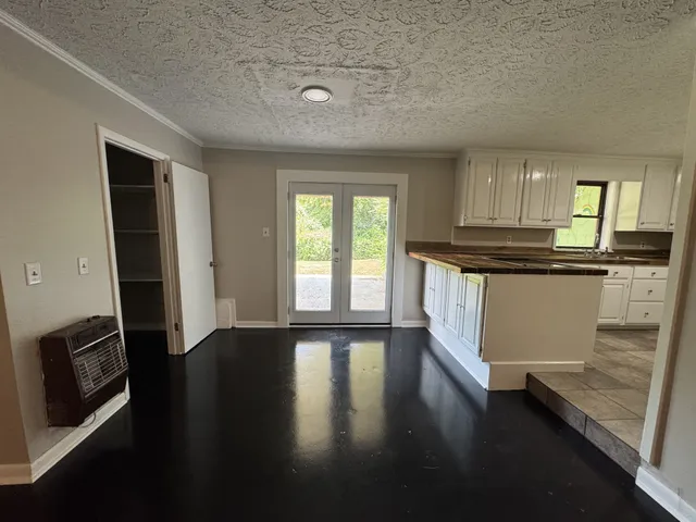 a kitchen with granite countertop wooden floors and wide window