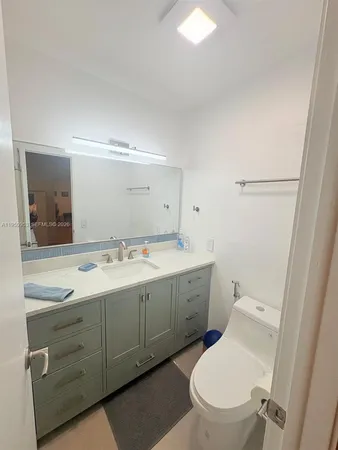 a bathroom with a toilet a sink and mirror