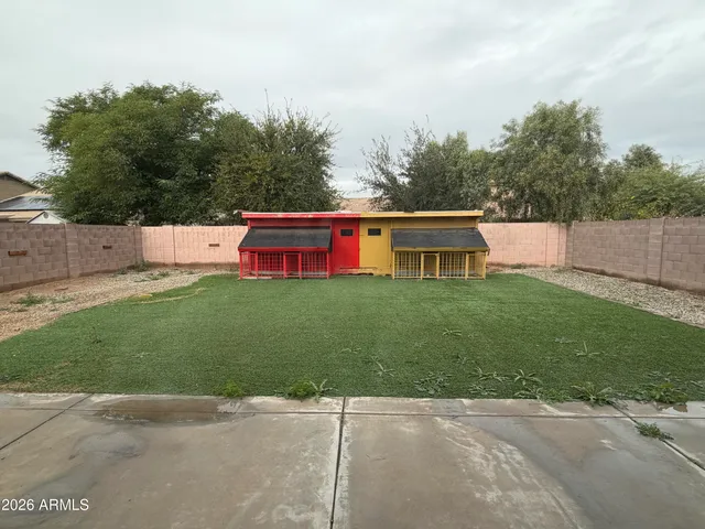 a view of a white house with a small yard and a big yard