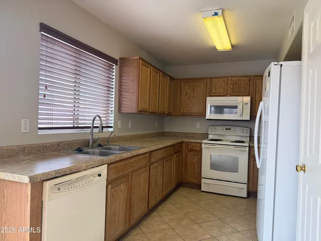 a kitchen with stainless steel appliances granite countertop a sink a stove a refrigerator and a window