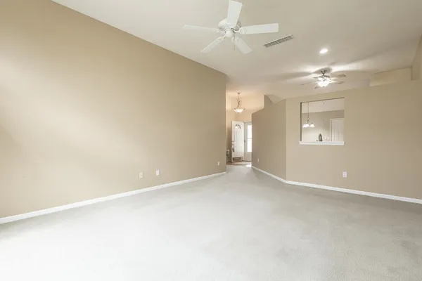 an empty room with a window and ceiling fan
