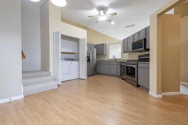 a view of a kitchen with a sink stainless steel appliances