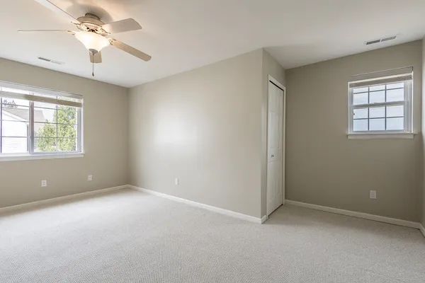 an empty room with a window and a ceiling fan