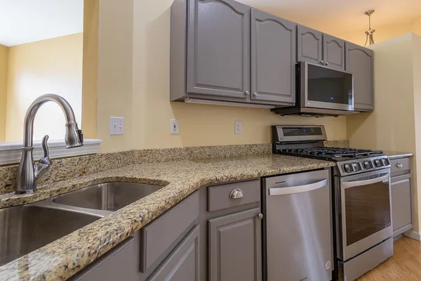 a kitchen with granite countertop a sink and a stove top oven