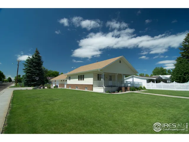 a big white house with a big yard and large trees