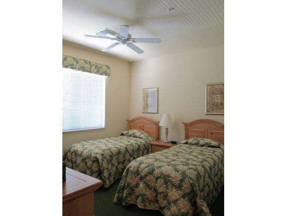 7920 Mahogany Run Lane, Unit 1024 Naples, FL 34113 - Photo 13 of 18 a bedroom with two beds and a chandelier