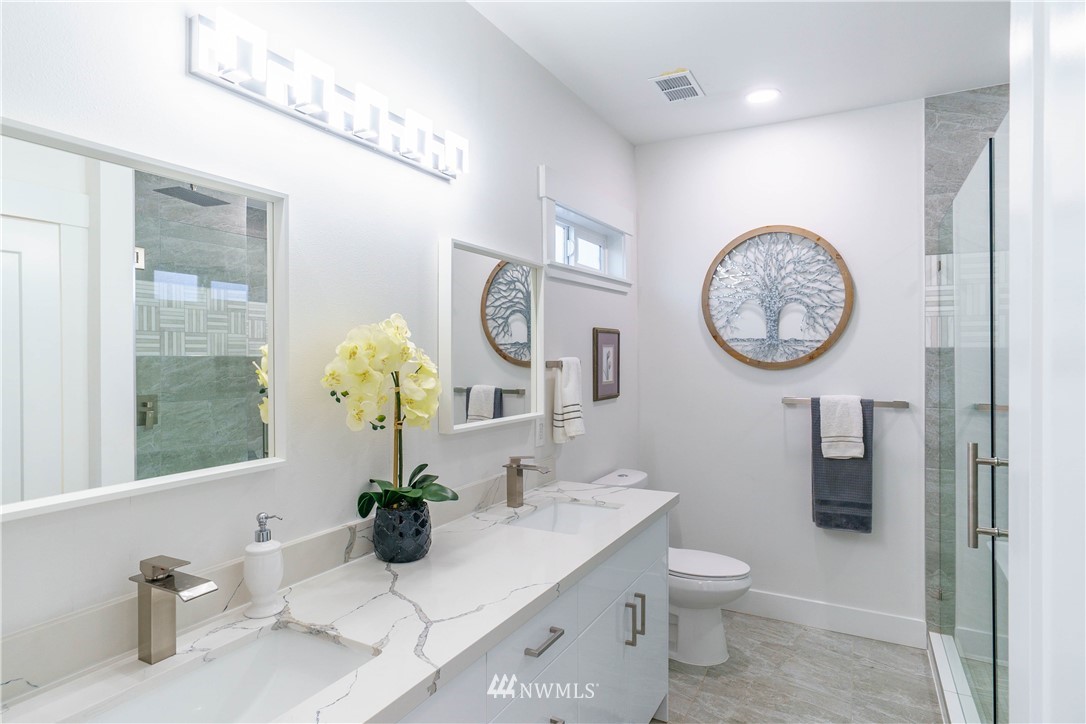 1129 North 84th Street Seattle, WA 98103 - Photo 11 of 24 a bathroom with a toilet a sink and a large mirror