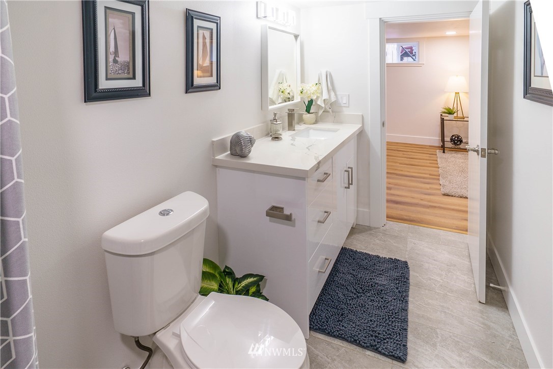 1129 North 84th Street Seattle, WA 98103 - Photo 21 of 24 a bathroom with a sink a toilet and mirror