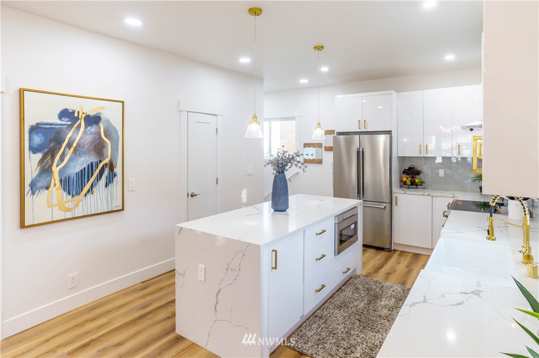 1129 North 84th Street Seattle, WA 98103 - Photo 6 of 24 a large white kitchen with a stove a refrigerator and a sink