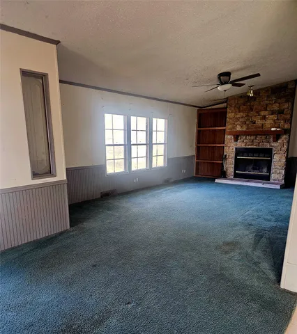 a view of an empty room with a fireplace and a window
