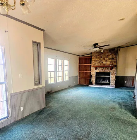an empty room with a fireplace and windows