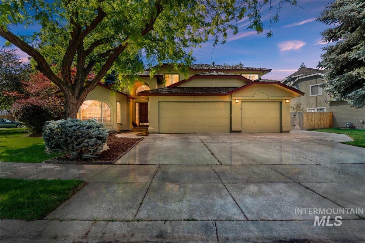 8001 West Innsbrook Court Boise, ID 83704 - Photo 1 of 39 Two-story property featuring a multi-car driveway, attached garage, mature front yard landscaping, and arched window details